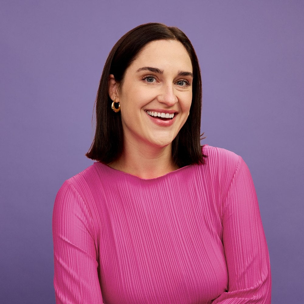 Kathryn Prigge, head of marketing at Calm Caterpillar, in a pink top against a purple backdrop.
