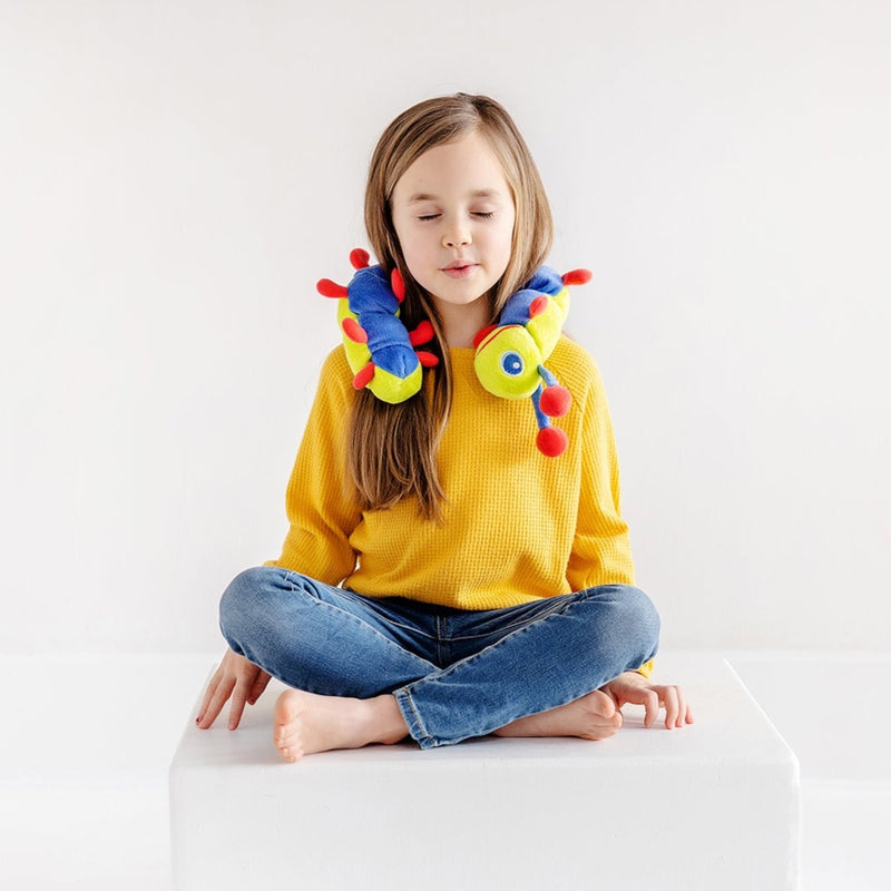 Image showing calmee the caterpillar on the shoulders of a child. Calmee is a soft-plush deep breathing tool, that enables children to have a sensory experience while they practice breathing.