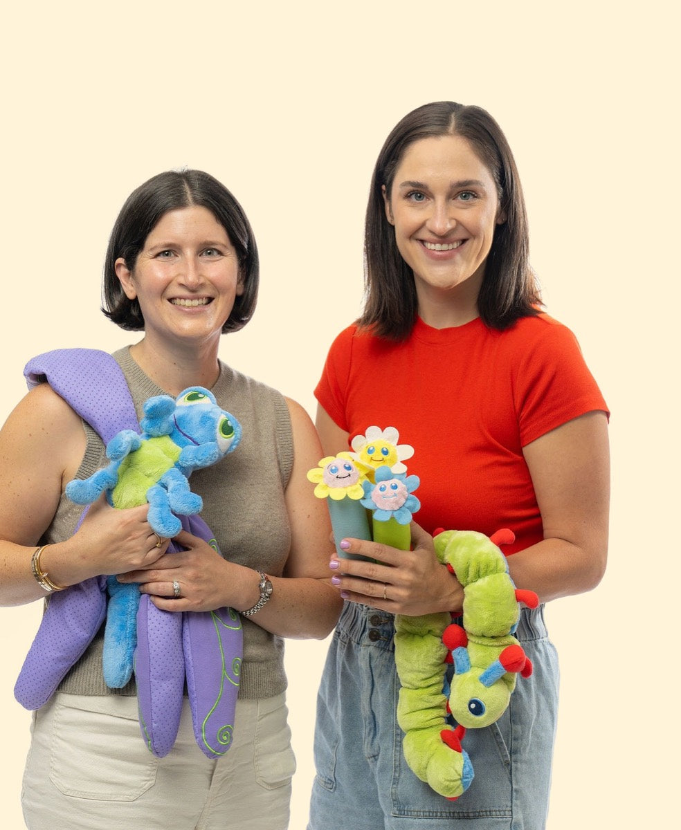Two members of the Calm Caterpillar team holding Flutter, Calmee, and the breathing sticks.
