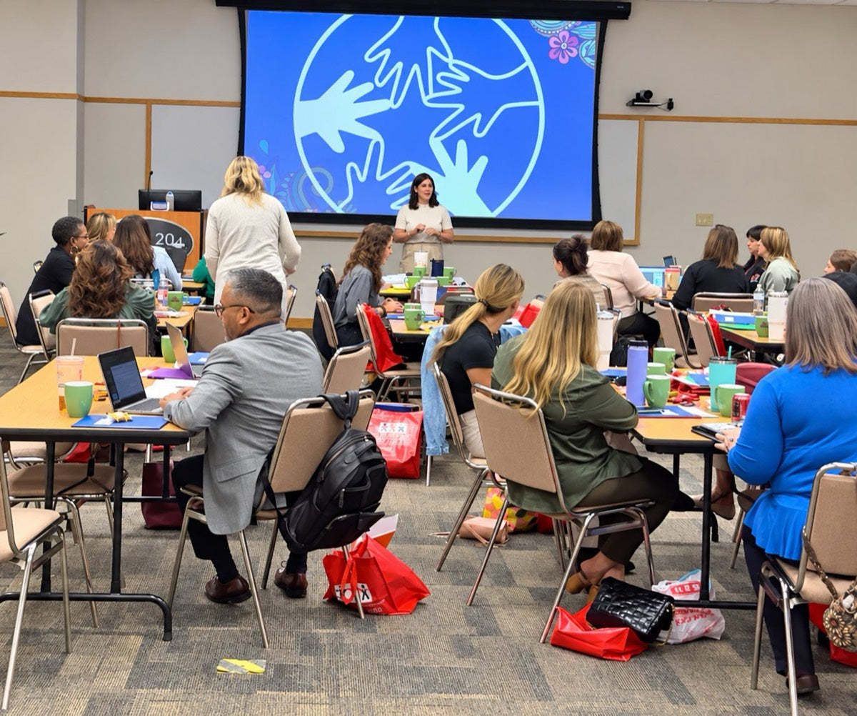 Sarah Habib presenting to a room of educators seated at tables during a Calm Caterpillar training.