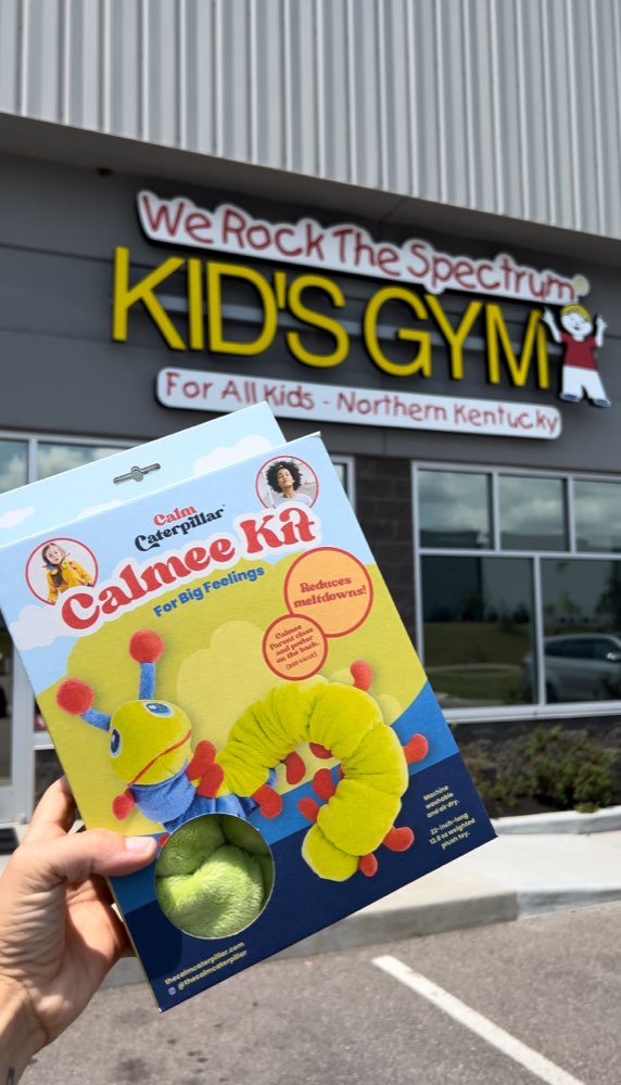 A boxed Calmee Kit held up outside a We Rock the Spectrum Kid's Gym in Northern Kentucky.