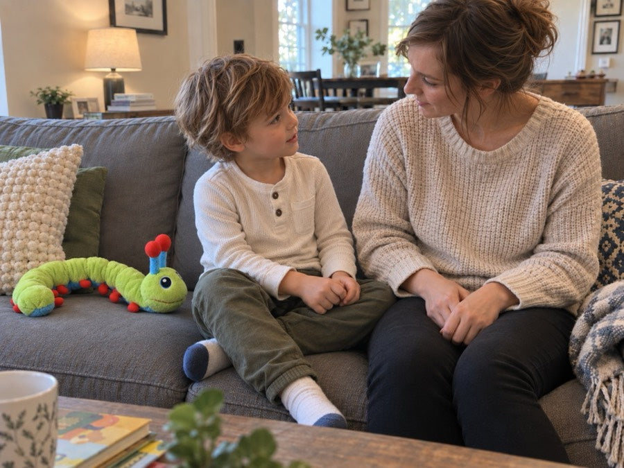 A boy and his mother sitting on the couch talking, with Calmee set down beside them.
