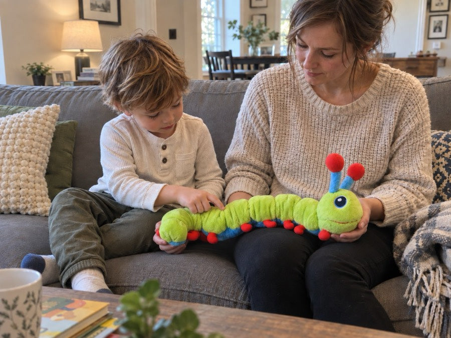 A parent holding Calmee across her lap on the couch while her son reaches over to press one of its segments.