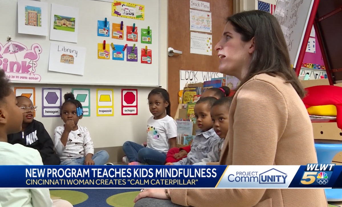 An adult sitting on a classroom rug talking with preschoolers during a Calm Caterpillar session.